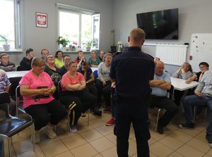 mł. asp. Damian Ostręga rozmawiającyz osobami niepełnosprawnymi