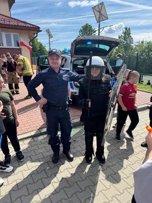 Policjant z dzieckiem wyposażonym w akcesoria policyjne