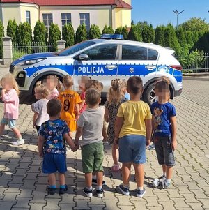 Dzieci z przedszkola w Sygneczowie stoją przed radiowozem policyjnym