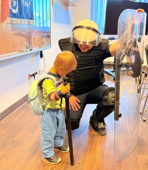 Policjant oraz przedskolak podczas prezentacji sprzętu policyjnego