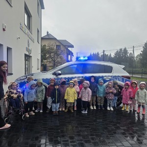 dzieci stojące przy radiowozie