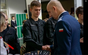 insp. Jarosław Klich gratuluje uczniowi klasy pierwszej