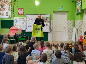 Dzielnicowy prezentujący kamizelkę odblaskową