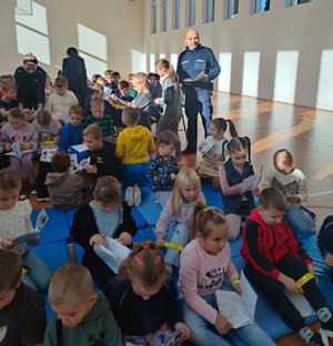 Policjanci rozdają kolorowanki oraz opaski odblaskowe