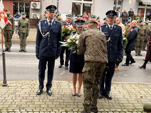 Delegacja KPP w Wieliczce przekazuje wiązankę kwiatów na ręce żołnierza