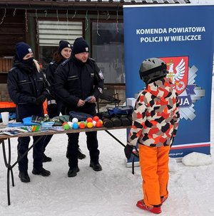 Policjanci KPP Wieliczka rozmawiają z dzieckiem przy stoisku