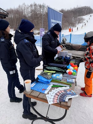 Policjanci rozmawiaja z osobami korzystającymi ze stoku