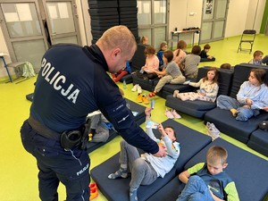 Policjant wręcza dzieciom ,, dekalog narciarza''.