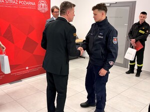 Komendant PSP Wieliczka składający gratulacje policjantowi KP Niepołomice