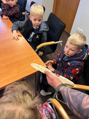 Policjant pokazujący dzieciom odcisk obuwia