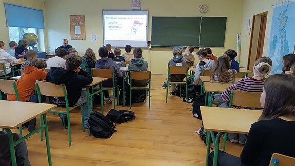 Policjant podczas prelekcji z klasą 7 Szkoły Podstawowej w Gdowie