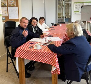 Policjant rozmawia z seniorami wielickiego klubu seniora