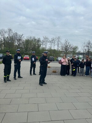 Policjanci oraz uczestnicy turnieju przed budynkiem szkoły podstawowej