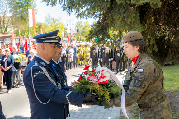 Policjanci przekazujący wiązankę