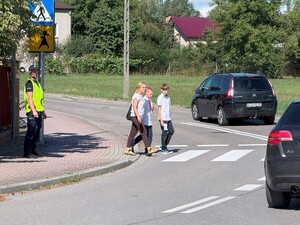 Policjant stojący przy przejściu dla pieszych w rejonie Szkoły Podstawowej w Gdowie