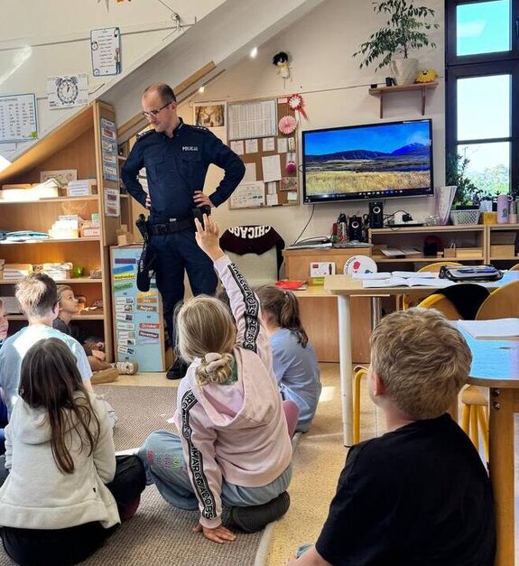 Dzielnicowy rozmawia z uczniami Szkoły Montessori