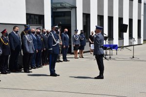 Dowódca uroczystości składa meldunek Komendantowi Wojewódzkiemu Policji w Krakowie. W tle odznaczeni samorządowcy