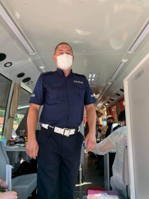 policjant przed oddaniem krwi w mobilnym autobusie