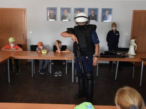 Policjant prezentuje wyposażenie w trakcie zabezpieczenia imprez masowych