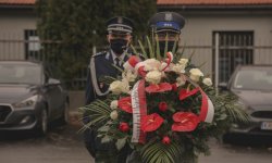 policjanci z wieńcem przed obeliskiem