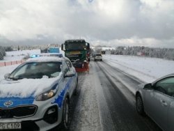 radiowóz policyjny poruszający się ośnieżoną drogą