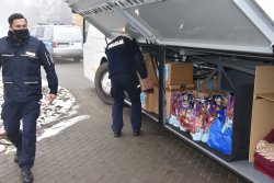 Policjanci pomagają w pakowaniu prezentów do autobusu